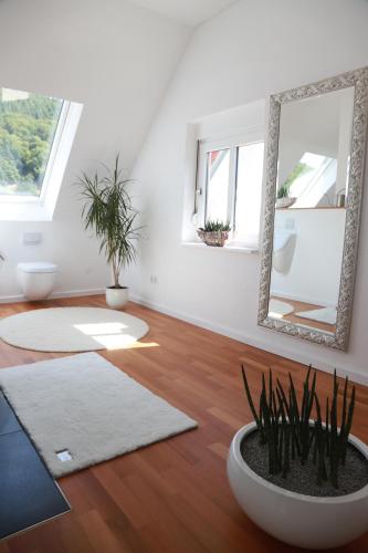 a living room with a mirror and a plant at Ferienwohnungen Ries in EuÃŸerthal