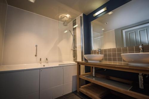a bathroom with two sinks and a large mirror at The Marquis of Granby in Alkham