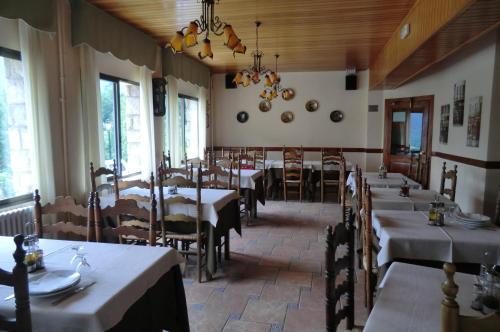 a restaurant with tables and chairs in a room at Pension Malida in Casau