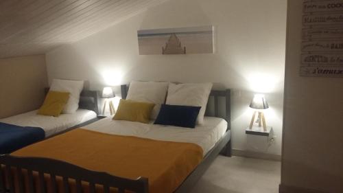 Dos camas en un dormitorio con dos lámparas. en L'Océane ( Résidence La Joséphine ), en Les Sables-dʼOlonne