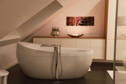 a bathroom with a white bath tub in a room at Ferienwohnungen Ries in EuÃŸerthal