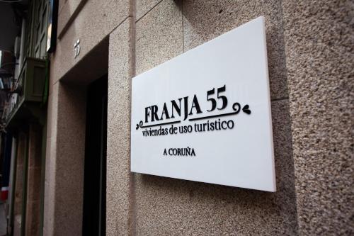 a white sign on the side of a building at APARTAMENTOS FRANJA 55 in A Coruña