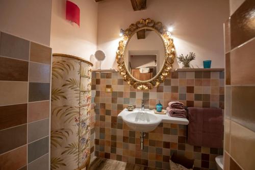 een badkamer met een wastafel en een spiegel bij La Casina di Pia in Montieri