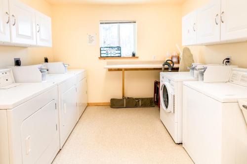 a white laundry room with a washer and dryer at Talkeetna Hideaway in Talkeetna
