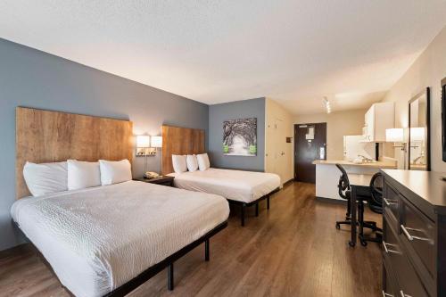 a hotel room with two beds and a desk at Extended Stay America Suites - Charlotte - University Place in Charlotte