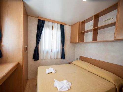 a bedroom with a bed with two white towels on it at Camping Village Mugello Verde in San Piero a Sieve