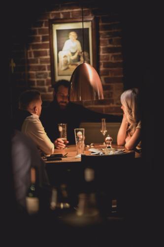 a group of people sitting around a table in a restaurant at The Marquis of Granby in Alkham