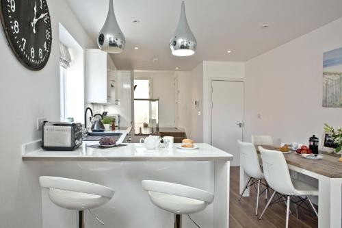 a kitchen and dining room with a counter and chairs at Sunnymead Penthouse - Close to beach, Pets welcome, Balcony in Exmouth
