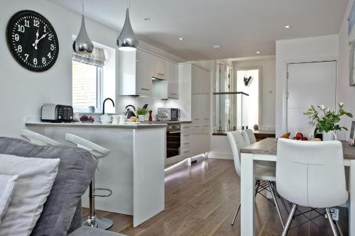a kitchen and dining room with a clock on the wall at Sunnymead Penthouse - Close to beach, Pets welcome, Balcony in Exmouth
