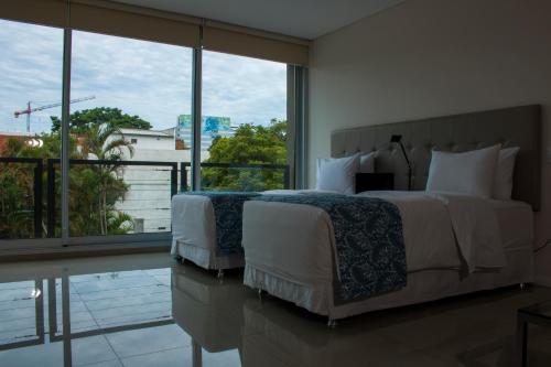 a bedroom with two beds and a large window at START Villa Morra Rent Apartments in Asuncion