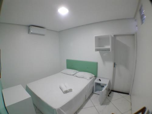Habitación blanca pequeña con cama y ducha en RAFAELLO HOTEL, en São Borja