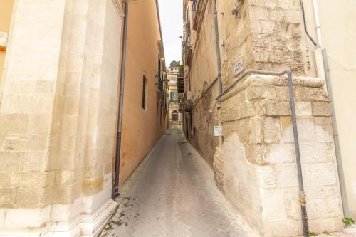 an alley between two buildings in an old town at U Dammusu in Modica