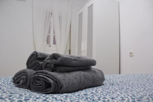 einen Stapel Handtücher auf dem Bett in der Unterkunft Estudio Malagueño Centro 1ºA in Málaga