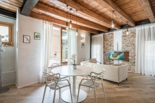 jadalnia i salon ze stołem i krzesłami w obiekcie Crocus Apartments w Sirmione