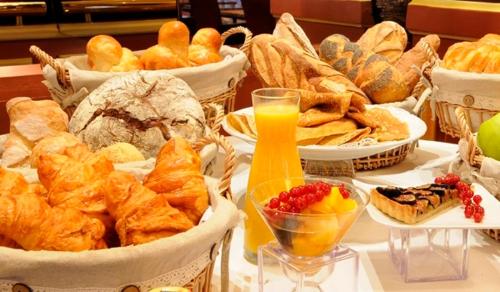 - une table avec de nombreux paniers de pain et de viennoiseries dans l'établissement Manoir Melphil, à Saint-Étienne-la-Thillaye