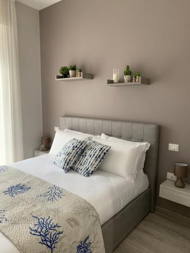 a bedroom with a bed with pillows and plants on the wall at B&B Il Crepuscolo - Pompei in Pompei