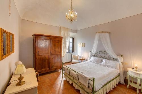 1 dormitorio con cama y lámpara de araña en La Rocca, en Gambassi Terme
