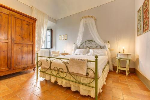 ein Schlafzimmer mit einem weißen Bett mit Baldachin in der Unterkunft La Rocca in Gambassi Terme