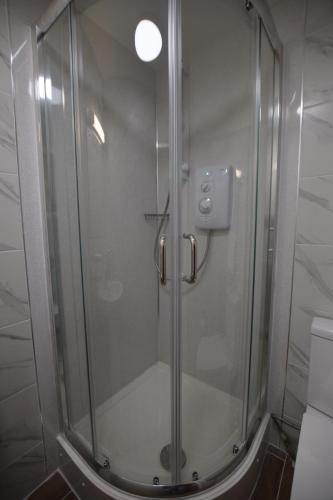a shower with a glass door in a bathroom at PremierLux Serviced Apartments in Ilford