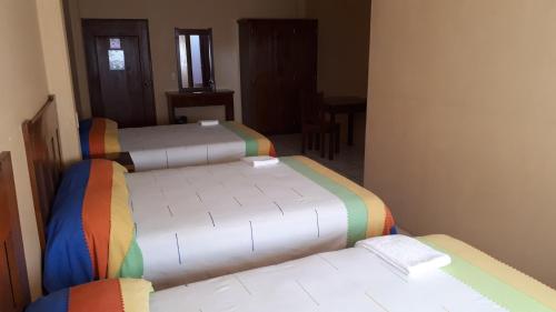 two beds in a small room with a room with twothirds at Hotel Alebrijes in San Pedro Pochutla