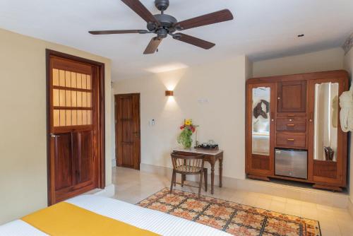a bedroom with a ceiling fan and a table at Verde Morada in Valladolid
