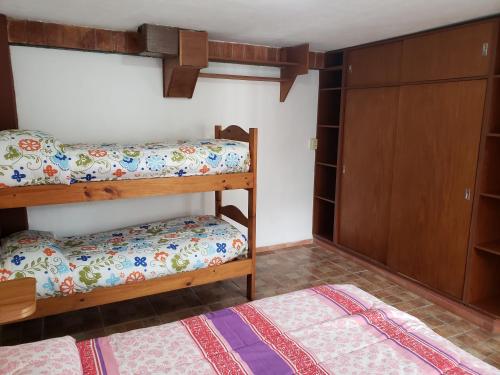 a bedroom with two bunk beds and a closet at Complejo La Naranjita in Rosario