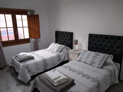 1 dormitorio con 2 camas y ventana en Casa confortable en Córdoba