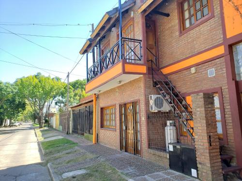 - un bâtiment en briques avec un balcon sur le côté dans l'établissement Complejo La Naranjita, à Rosario