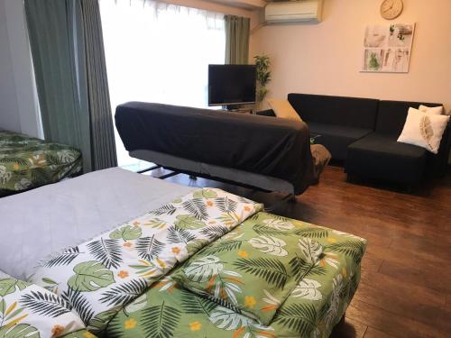a living room with a couch and a futon at Lipelala Stay 505 in Osaka