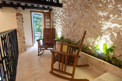 a living room with two chairs and a plant at Verde Morada in Valladolid