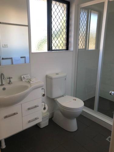 e bagno con servizi igienici, lavandino e doccia. di Biloela Palms Motor Inn a Biloela