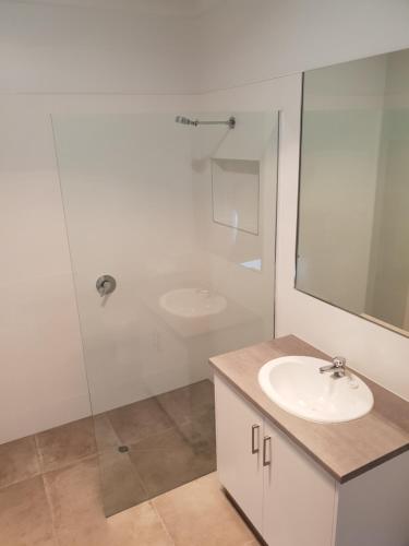 a white bathroom with a sink and a shower at Wimmera Plains in Horsham