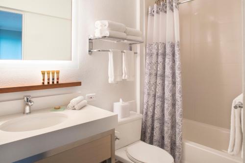 La salle de bains est pourvue d'un lavabo, de toilettes et d'une douche. dans l'établissement Queen Kapiolani Hotel, à Honolulu