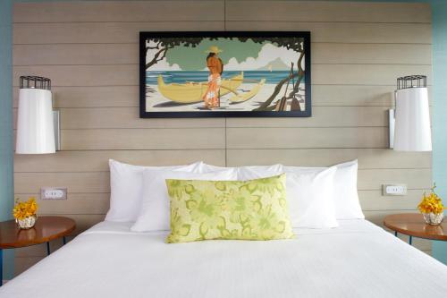 a bedroom with a bed and a painting on the wall at Queen Kapiolani Hotel in Honolulu
