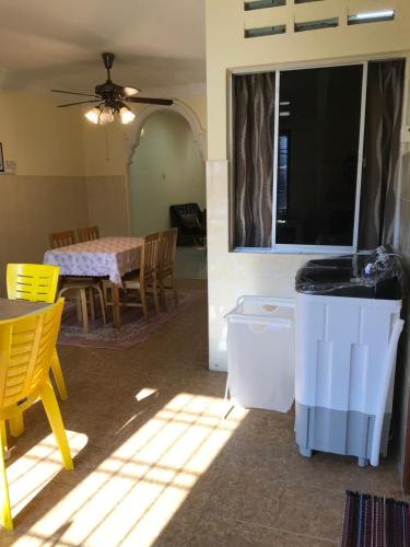 a kitchen and dining room with a table and yellow chairs at KERAI GUEST HOUSE TEMERLOH in Kampong Telok Mengkuang