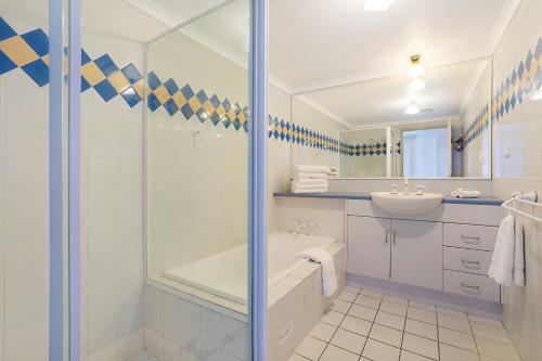 a bathroom with a shower and a sink at Newcastle Short Stay Accommodation - Sandbar Newcastle Beach in Newcastle