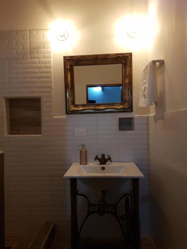 a bathroom with a sink and a mirror on the wall at Casa Isabelita in Mompos