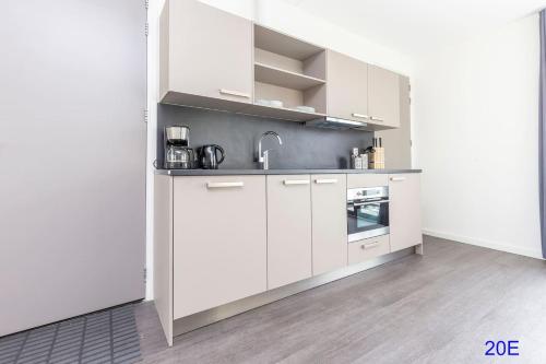 a kitchen with white cabinets and a sink at New Delft City view central modern family top floor apartment Utopia 20e in Delft