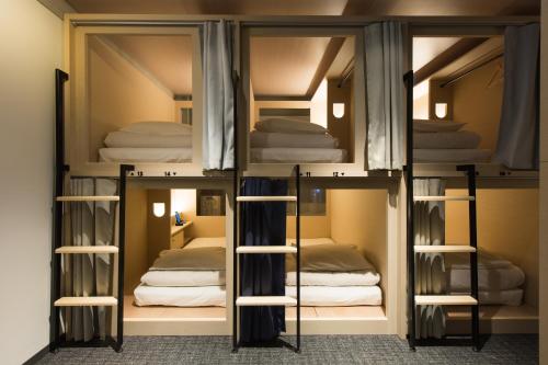 pokój z 3 łóżkami piętrowymi w pokoju w obiekcie UNPLAN Shinjuku w Tokio