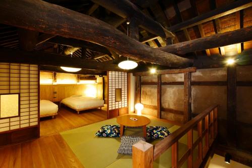 a bedroom with a bed and a table in a room at NIPPONIA Sawara Merchant Town Hotel in Katori