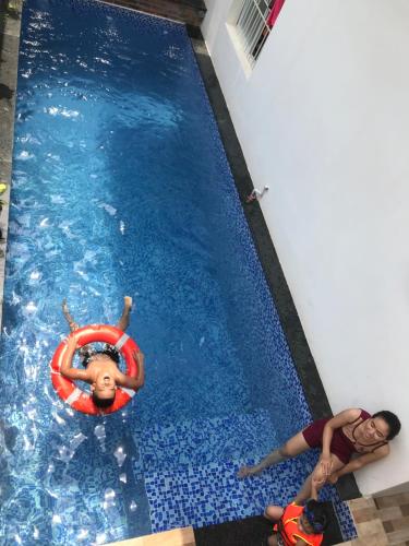 two children in a swimming pool with a life preserver at Hue Four Seasons Hotel in Hue