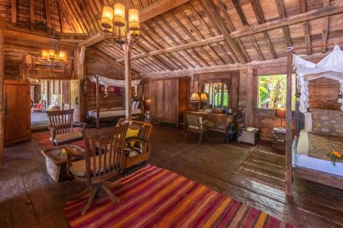 a large room with a bedroom and a bed and a desk at Ratua Private Island Resort in Aimbuei Bay