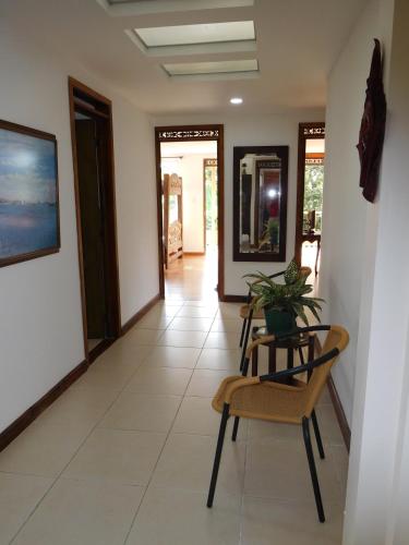 a hallway with chairs and a table with a plant at Casa Campestre La Quinfalia in Luna Park