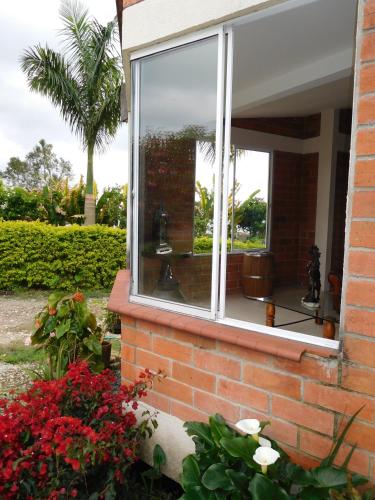 a window on the side of a house with flowers at Casa Campestre La Quinfalia in Luna Park