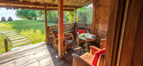 a porch of a cabin with a table and chairs at Ratua Private Island Resort in Aimbuei Bay