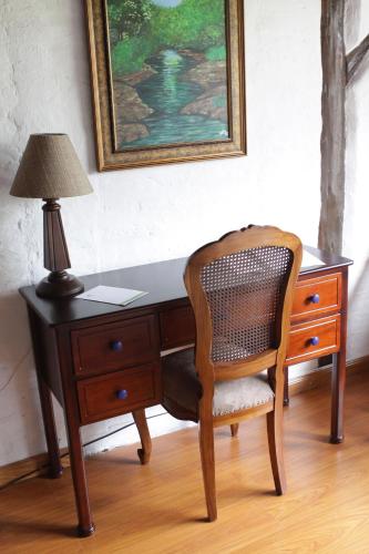 a desk with a lamp and a chair in a room at Casa d'Campo Tababela Hotel Boutique in Tababela