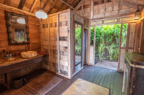 a bathroom with a shower in a wooden house at Ratua Private Island Resort in Aimbuei Bay