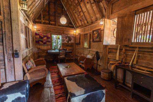a living room with wooden walls and wooden furniture at Ratua Private Island Resort in Aimbuei Bay