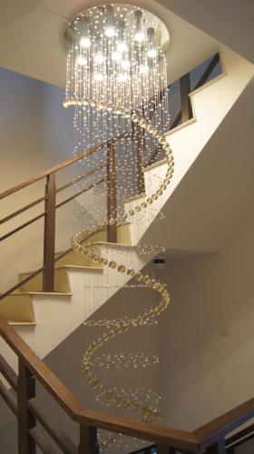 a large chandelier hangs from the ceiling of a staircase at 野居海景渡假民宿Simple Life Home Stay in Magong