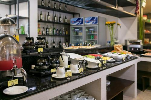 a buffet line with plates and cups on a counter at Azure Sapa Hotel in Sa Pa